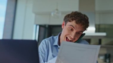 Ofiste cep telefonu okuma dokümanlarını yakından inceleyen neşeli bir yönetici. Gülümseyen adam evde akıllı telefon konuşmalarıyla iş fikirlerini tartışıyor. Neşeli çalışanın portresi, mutlu iletişimin keyfini çıkar..