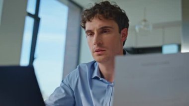 Modern ofiste çalışan ciddi bir profesyonel. Odaklanmış dikkatle gazete okuyor. Düşünceli iş adamı proje hakkındaki raporları analiz ediyor. Kararları düşünen konsantre genç bir adam..