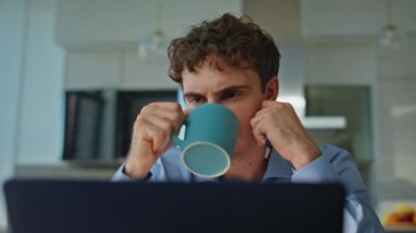 Ofis müdürü iş yerinde kahve içerek çözüm buluyor. Ev işyerinde sıcak içeceğin keyfini çıkaran dizüstü bilgisayara odaklanmış bir adam. Düşünceli erkek çalışan yudum yudum düşünüyor..