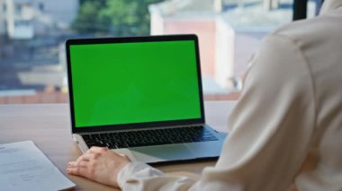 Ofis masasında oturan iş kadını yeşil ekran dizüstü bilgisayarı gibi görünüyor. Şirketin çalışma alanındaki Chroma Key Bilgisayar 'da çalışan kimliği belirsiz bir kadın. İş ortamında modelleme aygıtı kullanan yönetici.