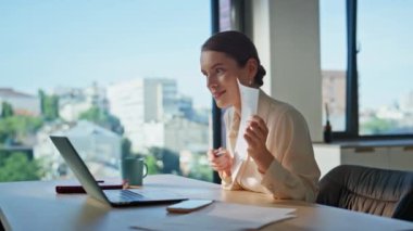 İnternetteki öğretmen bilgisayar kamerasında evrakları gösteriyor. Modern iş yerinde yakın çekimde oturuyor. Ofisteki sanal toplantıda belgeyi sunan iş kadını. Sözleşmenin detaylarını video çağrısı ile açıklayan yönetici.