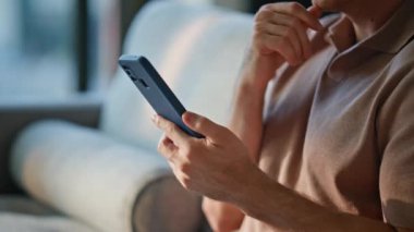 Adam cep telefonu ekranını araklıyor ve yakın çekimde online alışverişleri seçiyor. Bilinmeyen adam rahat koltukta oturmuş akıllı telefon mesajlarına bakıyor. Öğrenci, apartman kanepesinde rahatça iletişim kuruyor..