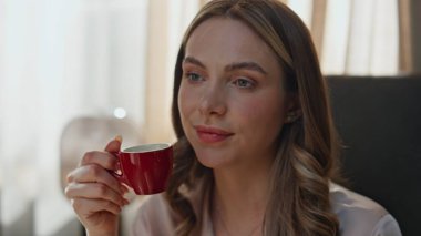 Sabah kadını yumuşak yatakta espresso yudumluyor. Sayfaları çeviren rahat kadın elleri rahat yatak odasına kahve fincanı koyuyor. Güzel, gülümseyen kadın çayını yudumlarken otelde kahvaltı yapıyor.