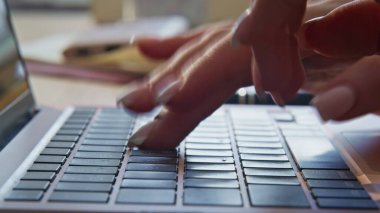 Kadın elleri kapalı mekanda klavye dizüstü bilgisayarı yazıyor. İş kadını ev ofisinin makro görüntüsünde parmaklarını bilgisayar tuşlarına basıyor. Bilinmeyen serbest çalışan, sadece ücra bir yerde çalışan modern aygıt kullanıyor. 