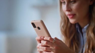Ev hanımı, hafta sonu ev içi kapatma programında mutfakta mesajlaşan cep telefonunu uzatıyor. Gülümseyen kadın akıllı telefon ekranında mutfak tezgahında dikiliyor. Cep telefonundan mesaj okuyan mutlu kız.