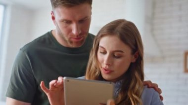 Sabah aşıkları mutfaktaki tableti yakından çekiyorlar. Çekici eş, yakışıklı koca bilgisayardan dijital tarif okuyor. Rahat bir çift, modern yemeklerden zevk alıyor. 