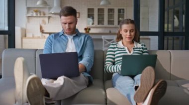 Serbest çalışan çift iç mekanda dizüstü bilgisayar çalışıyor. Mutlu karı koca birlikte oturup bilgisayar yazıyorlar. Birlikte uzak bir iş yerinde internete girip online iş yapmaktan keyif almak.