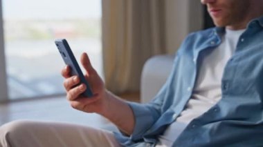 Yakın plan adam akıllı telefon alışverişini evdeki kanepede yapıyor. Sevgilisi cep telefonlarını yan yana oturtmuş. Sıkıcı eşler cep telefonu görünümlü ekranlar birbirlerini görmezden geliyorlar