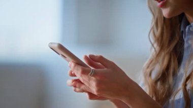 Kız elleri cep telefonuyla pencerelerin önünde sabah kahvesinin keyfini çıkarıyor. Lüks bir dairede akıllı telefon mesajı yazan gülümseyen bir kadın. Mutlu bayan internette sörf yapıyor. 