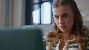 Evde dizüstü bilgisayar yazan bir kadın ev içi boş zamanların tadını çıkarıyor. Uzaktan kumandalı kablosuz bilgisayar oturma katında çalışan ciddi bir serbest çalışan kadın. Genç bayan açık bir apartmanda online proje düşünüyor. 