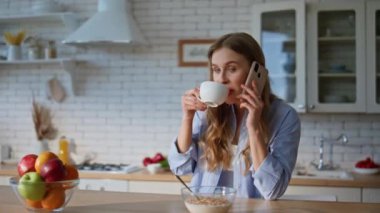 Ev mutfağında cep telefonuyla kahve içen bir kadını aramak. Hafta sonu evde akıllı telefonlardan konuşan çekici, rahat bir kadın. Evcil kız cep telefonuyla sabah içkisinin tadını çıkarıyor. 