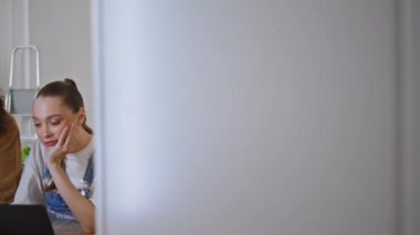 Kız arkadaş dizüstü bilgisayarın e-ticaret mağazası planlama ev dekorunu tartışıyor. Rahatlamış aile fertleri bilgisayar ekranına bakıyor. Fikirlerini paylaşıyorlar. Yeni bir daire. Mutlu eşler çevrimiçi geziniyor.