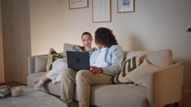 Dizüstü bilgisayarda rahat koltukta oturan çift e-ticaret mağazası hakkında konuşuyor. Mutlu eşler bilgisayar ekranına bakıyor ve modern oturma odasında dinleniyorlar. Romantik çift izlemek için film seçiyor.