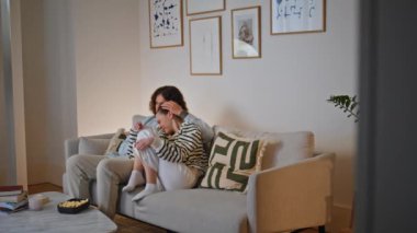 Koca, aile akşamında rahat bir kanepede korku filmi seyreden karısına sarılıyor. Erkek erkeğe sarılan genç bir kadın kendini güvende ve sevilmiş hissediyor. Evli çift, TV 'de rahat bir koltukta oturup gerilimin tadını çıkarıyor..