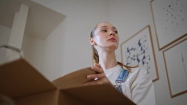 Yeni sahibi kendi evinde karton kutuları açıyor düşünceli bir şekilde yakın plan çekiyor. Sakin bir kadın ev eşyaları için bir yer arıyor. Genç bir kadın boks dekorunu değiştiriyor. Evin içini düzenliyor..