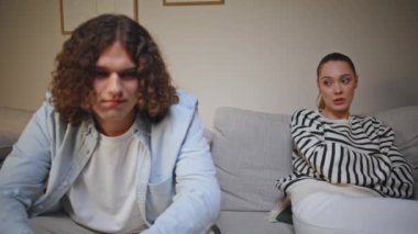 Kanepe dairesinde kavga eden evli çiftler. Kanepede oturup erkek istismarından yakınan endişeli bir kadın. Evde ilişki sorununu düşünen kıvırcık saçlı bir adam. Aile krizi konsepti.