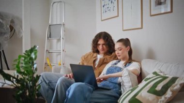 Eşler rahat kanepe zoom 'unda iç dizayn planlıyorlar. Rahat evli bir çift online mobilya dükkanında rahat bir oturma odası kanepesinde oturuyor. Aile çifti bilgisayar mağazasını tartışıyor