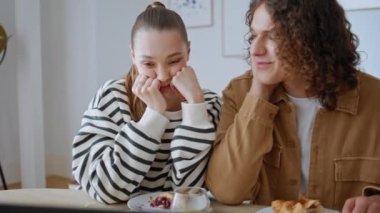 Kahvaltıdan sonra kucaklaşan sevgi dolu bir çift. Gülümseyen kıvırcık saçlı, güzel karısını kucaklayan, modern bir dairede oturan adam. Romantik eşler evcil sabahın keyfini çıkarıyorlar.. 