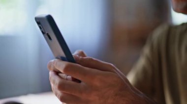 Yönetici ofiste mesajlaşan cep telefonuyla mesajlaşan kişilere yakın çekim yapıyor. Mutlu serbest çalışan adam iş yerinde cep telefonu mesajı okuyor. Genç, pozitif iş adamı gülümseyen akıllı telefon ekranı