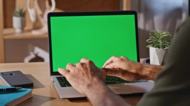 Modern güneşli iş yerindeki Chromakey dizüstü bilgisayarda e-posta yazıyor. Şirket ofisindeki yeşil ekran bilgisayarda çalışan tanınmayan bir adam. İş adamı evde internet araştırması yapıyor 