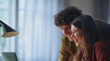 Sakin aile sabahında dizüstü bilgisayar seyreden gülen sevgililer. Mutfakta bilgisayar ekranını işaret eden komediden hoşlanan pozitif bir çift. Mutlu romantik aşıklar güneş ışığında birlikte eğleniyorlar. 