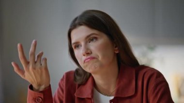 Kendine güvenen bir iş kadını rahat bir dairede oturmuş video konferansında konuşuyor. Odaklanmış kadın yönetici, laptop kamerasıyla partnerleriyle çevrimiçi iletişim kuruyor. Evde uzaktan çalışan bir kız.