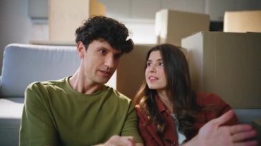 Ev sahipleri, yeni ev satın alınan oturma odasında ev içi kucaklaşmayı tartışıyor. Evli çift modern daireye taşınmayı seviyor. Mutlu genç eşler birlikte ipotekli ev tasarlamayı planlıyorlar.