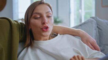 İlham verici kız arkadaş, internetten erkek arkadaş alışverişi yapıyor. Evde kapalı kapılar ardında. Malları seçerken ekranda el kol hareketi yapan mutlu duygusal kadın. Genç çift evde birlikte dinleniyor. 