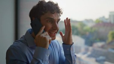 Ofis penceresinden cep telefonunu arayan kızgın CEO 'nun portresi. Akıllı telefonda tartışan sinirli iş adamı içeride iş sorunları yaşıyor. Öfkeli patron cep telefonu konuşmalarında bağırıyor. Stres altında..