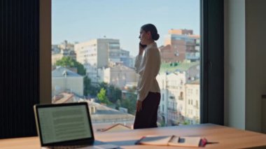 Ofis panoramik penceresinde telefonla konuşan sinirli kadın. Sinirli iş kadını akıllı telefon konuşmasını bitirdi. Tatminsiz kötü haber. Stresli bayan evde cep telefonu iletişimi konusunda endişeli.