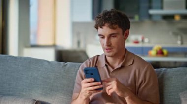 Ev sahibi, rahat kanepe kapanışında akıllı telefon uygulamasına bakıyor. Dairedeki cep telefonu uygulamasını kullanarak internetten alışveriş yapan rahat bir erkek. Cep telefonundan mesaj okuyan sakin adam hafta sonunun keyfini çıkar.