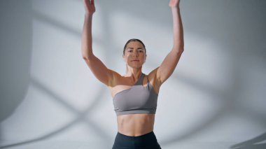 Düşünceli kadın sabahları namaste asana yapıyor. Sakin bayan tek başına meditasyon yapıyor. Huzurlu bir evde kameraya bakıyor. Gözleri kapalı, yoga yapan, el kaldıran bir kız. Uyum kavramı 