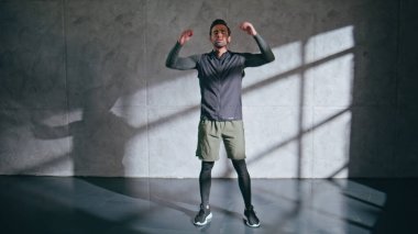 Erkek vücut geliştirici vücut ısıtıyor. Spor salonundaki spor salonunda her gün elini uzatan fitness adamı. Esmer sporcu fiziksel egzersizde el kaldırıyor. Sadece spor kulübünde iyi bir sporcu. 