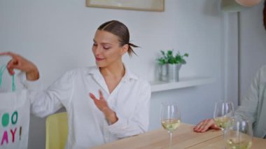 Gülümseyen kız, doğum günü partisinde arkadaşına hediye veriyor. Mutlu adam dekore edilmiş oturma odasına bakıyor. Çeşitli insanlar kutlama yıldönümlerinde eğleniyor.