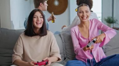 Duygusal kızlar birlikte oynuyorlar. Yakın planda evde iyi eğlenceler. Video oyuncular, arkadaşlarıyla oturma odasında oturan yarışma zaferini kutluyorlar. Mutlu oyuncular apartman dairesinde eğleniyor.