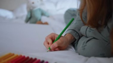 Kapanış çocuğu hafta sonları kağıda kalem çizer. Bilinmeyen bir kız beyaz yatakta oturuyor ve iç mekânda görüntü yaratıyor. Tanımlanamayan bir çocuk odasında tek başına vakit geçiriyor. Mutlu çocukluk kavramı