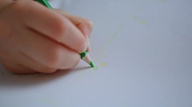 Yeni yürümeye başlayan çocuğun elleri kapalı mekanda otururken resmini boyuyor. Bilinmeyen küçük kız hafta sonu albümünde resim yapıyor. Yaratıcı çocuk yeşil renk çizmekten zevk alıyor. Çocukluk ve yaratıcılık kavramı