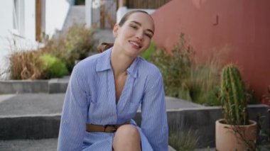 Merdivenlerde poz veren sevimli çekici kadın, hafta sonunu şehirde geçirmenin keyfini çıkarıyor. Tasasız model kız güzel bir yaz verandasında sokak merdivenlerinde oturuyor. Rahat genç bayan turist rahat bir kasabada kameraya bakıyor.