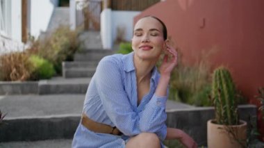 Eski kasaba sokak portresine bakan merdivenlerde oturan nazik bir model. Romantik kaygısız kadın poz veriyor yaz haftasonunun tadını çıkarıyor. Mimariyi tek başına düşünen mutlu tatlı bayan. Boş zaman konsepti