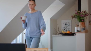 Elinde kahve fincanı tutan, rahat rahat yürüyen sakin bir kadın. Rahat bayan, sıcak bir içecek ile yalnızlığın tadını çıkarın. İş yerinde yakın çekim yapın. Müdür güne sakin bir sabahta işten zevk alarak başlıyor. 