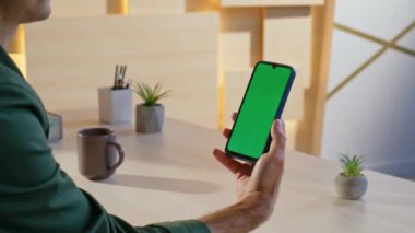 Çağdaş iş yerindeki cep telefonunda Freelancer mesajı okuyor. İşadamı yeşil ekran cep telefonu tarama uygulamasını dinliyor. Bilinmeyen adam menejeri, sosyal medyayı aygıtta izliyor.