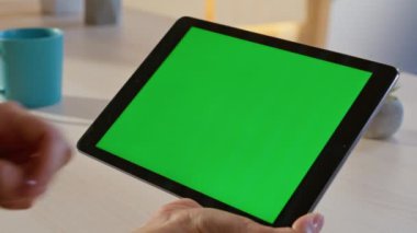 Programcı, ofiste yeşil ekran tablet tarama uygulamasını kapatıyor. Bilinmeyen bir kadın Chroma Key Pad bilgisayarından online alım yapmayı seçiyor. İş yerindeki kadın elleri modelleme cihazına dokunuyor.