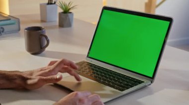 Girişimci tarama uygulaması şirket ofisindeki yeşil ekran laptopunda. Bilinmeyen serbest çalışan eller Chroma Key Bilgisayar 'ın eğitici videosunu açıyor. Model dijital aygıtında çalışan işadamı.