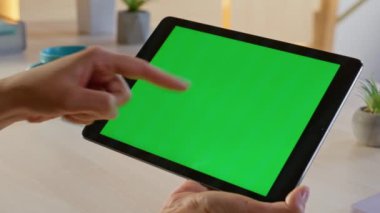 Çevrimiçi yönetici uzak iş yerinde tablet tarama web sitesi kullanıyor. Meçhul iş kadını elleri ofiste yeşil ekranlı bilgisayara kayıyor. Krom anahtar üzerinde çalışan serbest çalışan bir bayan.