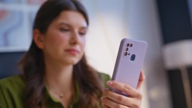İş yerindeki portre işkadını cep telefonunu işaret ediyor. Kendine güvenen esmer kadın ofisteki akıllı telefonda online başvuru yapıyor. Başarılı kadın yönetici cep telefonu iletisini tarıyor.