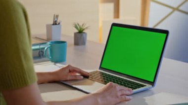 Konforlu iş yerinde uzaktan kumanda yeşil ekran dizüstü bilgisayarı arıyor. Bilinmeyen iş kadını şirket ofisinde krom anahtar bilgisayara bakıyor. Mockup pc aygıtında webinar izleyen kız öğrenci.
