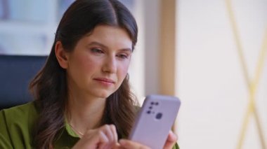 Cep telefonundan alışveriş yapan kız modern apartman dairesinin yakın çekimlerinden memnun kaldı. Gülümseyen kadın cep telefonundan maaş bildirimi alıyor. Akıllı telefon mesajlarına bakan mutlu bayan.