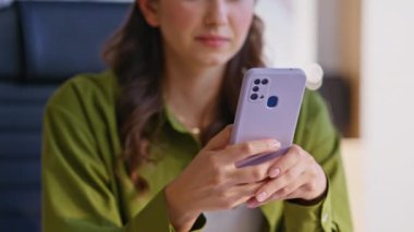 İş yerinde cep telefonuyla mesajlaşan şık bir kız. Genç esmer eller şirket ofisinden akıllı telefon mesajı yolluyor. Kendine güvenen iş kadını. Yeşil gömlekli. Kapalı alanda cep telefonuna SMS yazıyor..