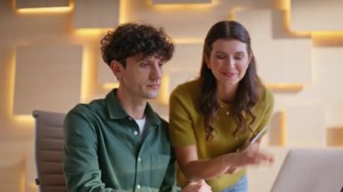 Modern ajans ofisindeki video toplantısında iş arkadaşlarını selamlıyorlar. Gülümseyen iş kadını yeni meslektaşını online konferansta dizüstü bilgisayarla sunuyor. Bilgisayar kamerasına el sallayan iki pozitif yönetici 