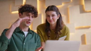 Modern iş yerindeki sanal konferansta başarılı ortaklar konuşuyor. Gülümseyen adam, video görüşmesiyle müşteriye danışıyor. İki meslektaş online toplantıda ekiple fikirleri tartışıyor..